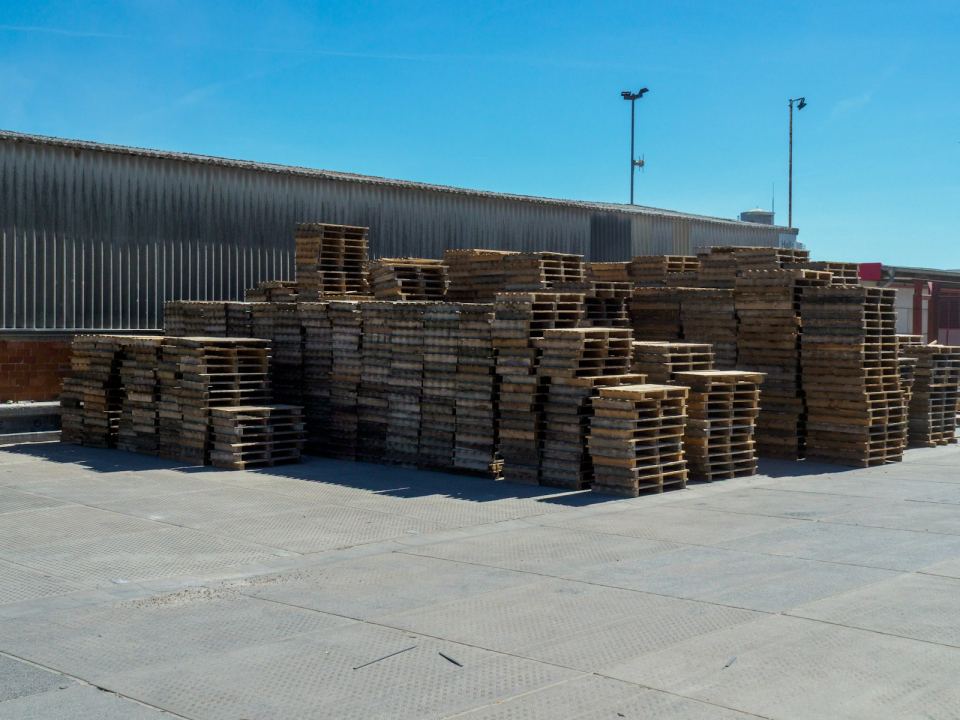 Timber pallets stacked outside a warehouse
