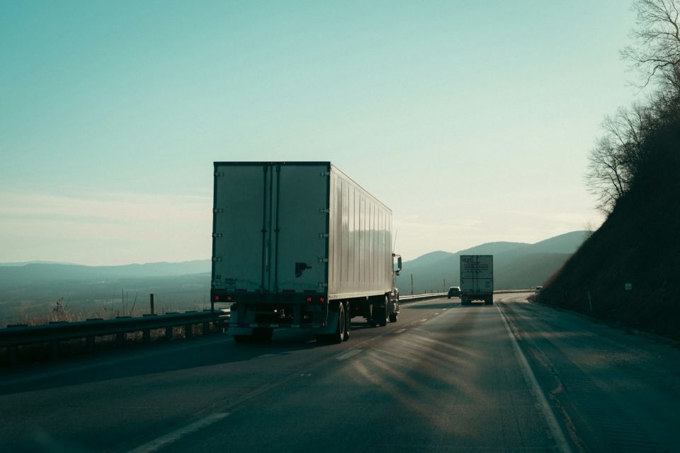 Two linehaul trucks running the highway at first light