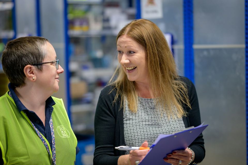 Warehouse staff checking stock against a clipboard